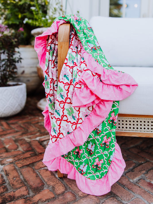 Colorful red, pink and green blanket draped over the arm of a couch.