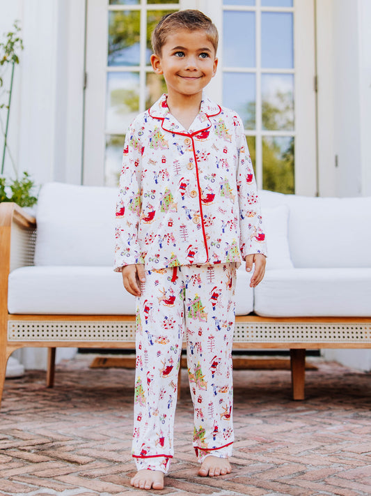Boy standing outside in front of white couth wearing a christmas pattern button set