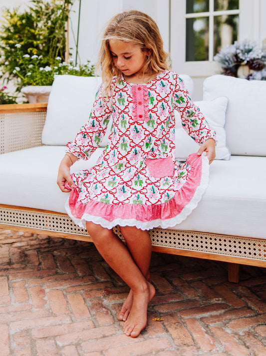 Girl sitting on couch outside wearing a dress and is holding the edges of both sides to make it look full.
