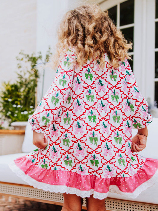 Backside of girl outside wearing a bow printed dress.