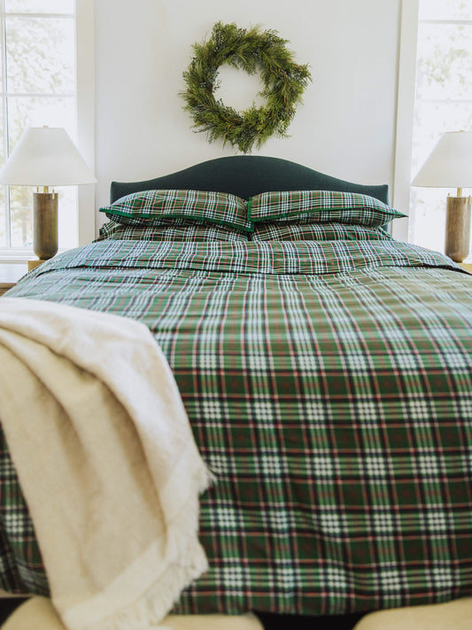 Green traditional plaid made bed with matching pillow cases.