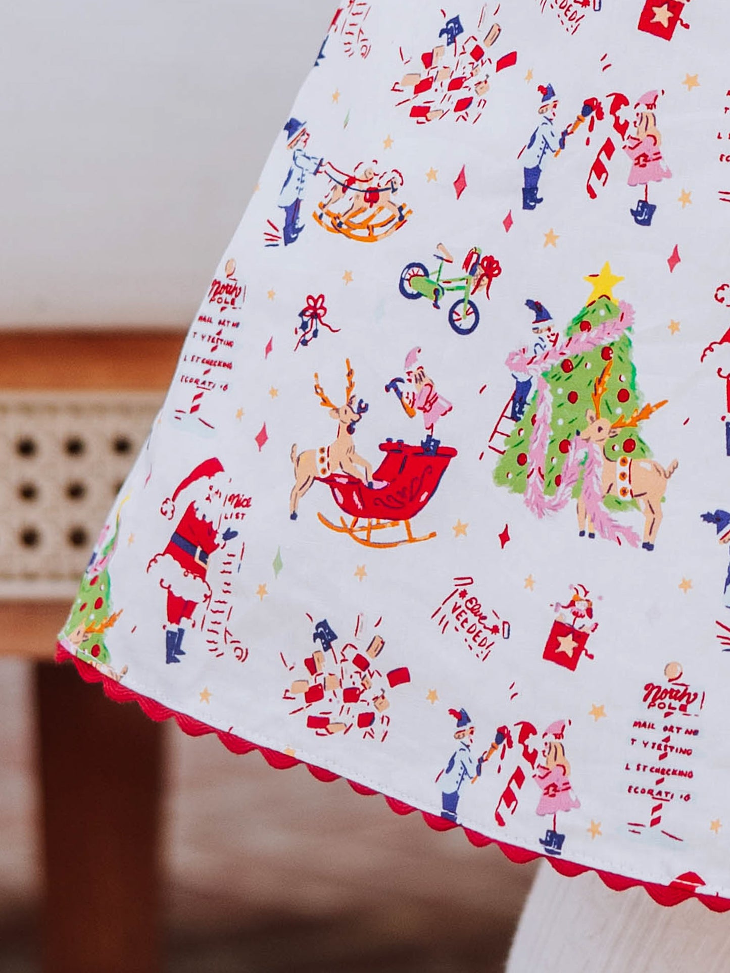 Close up of Holiday printed dress with ric rac trim at hem