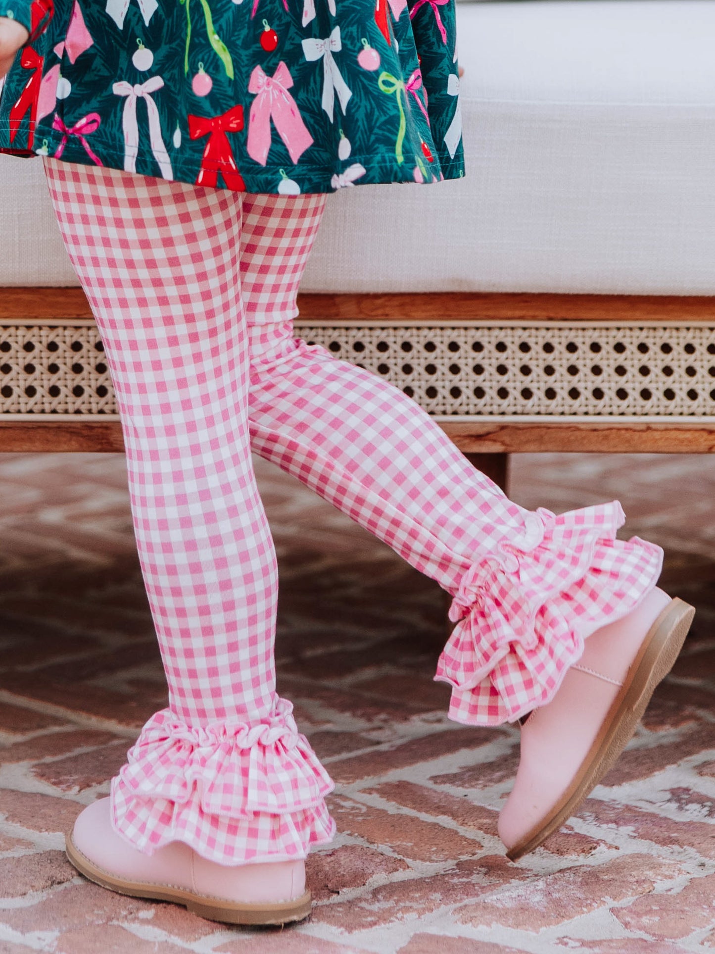 Pink gingham bottoms with ruffles at ankles. Model is also wearing pink buckle shoes.