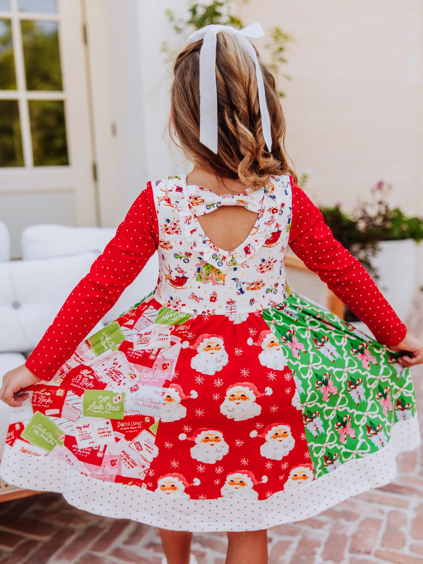 Backside of quirky holiday themed dress. You can see all of the different prints as well as the scoop ruffled back.