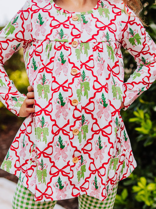 Holiday bow themed top with wooden buttons going down. Bottoms are green gingham.