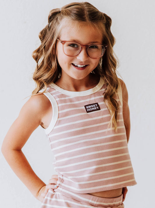 Model is wearing a pink and ivory striped two piece skort set. There is a sweethoney stitched tag on the middle of chest of shirt.