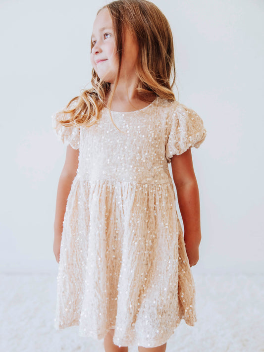 Make every moment shine in our Girls’ Sequin Sparkle Dress, designed for holiday parties, special occasions, and picture-perfect moments. Crafted from 100% polyester, this dress features a soft velvet-like texture that’s gentle on the skin and a smooth interior lining for all-day comfort. The fabric is covered in shimmering transparent sequins that catch the light beautifully, creating a dazzling effect with every twirl.