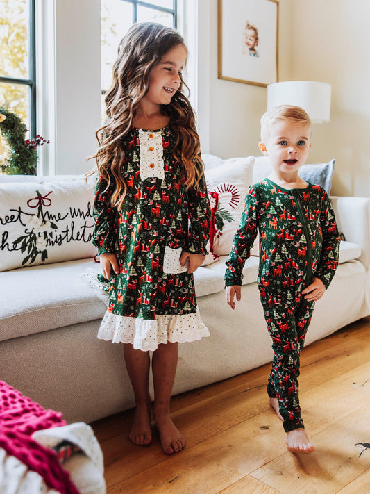 This everyday play dress features an array of sleighs, Christmas trees, reindeer and more. Perfect for the holidays, this Mystic Forest print brings festive charm and timeless style. Designed with classic charm and sweet details, this girls’ Mystic Forest dress is ideal for family photos, lounge and play. The soft, lightweight fabric ensures all-day comfort, while the twirl-worthy skirt adds a playful touch. A must-have addition to her holiday wardrobe!