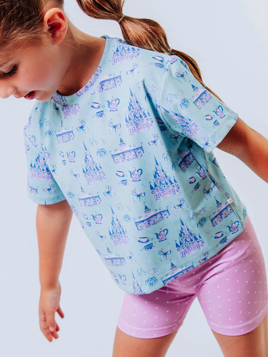 Serve up style and fun with our girls’ “Most Magical” active set, designed for comfort, movement, and everyday play. This adorable sleeveless dress features a whimsical print inspired by magical castles, carousels, and fairy-tale adventures — perfect for little dreamers who love both sports and sparkle. The lightweight, stretchy performance fabric keeps her cool and comfortable from the court to the playground, while the flowy shirt design and active shorts allows for easy twirls and active fun.