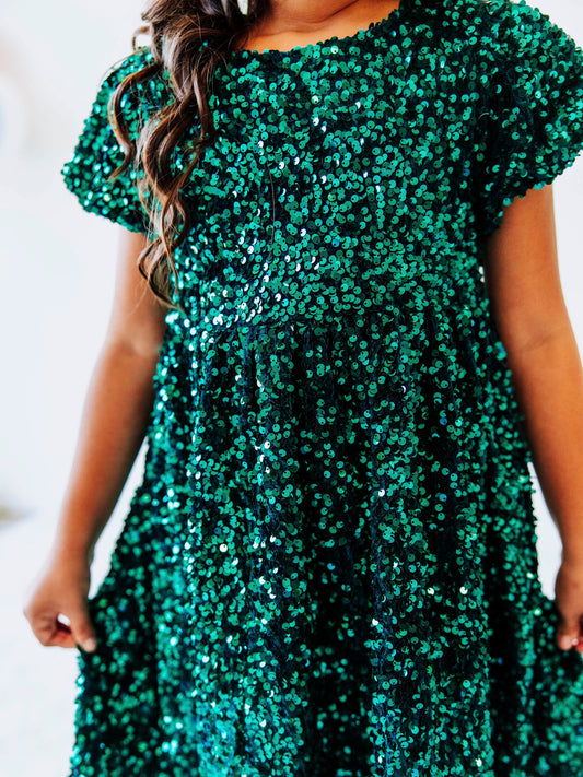 Make her holiday sparkle in our girls’ emerald green sequin dress, designed for festive celebrations, special occasions, and twirl-worthy moments. This stunning sparkle party dress for girls features an allover layer of shimmering green sequins that catch the light from every angle. With a soft interior lining and comfortable puff sleeves, it’s as cozy as it is glamorous.
Perfect for Christmas parties, family photos, and holiday events.