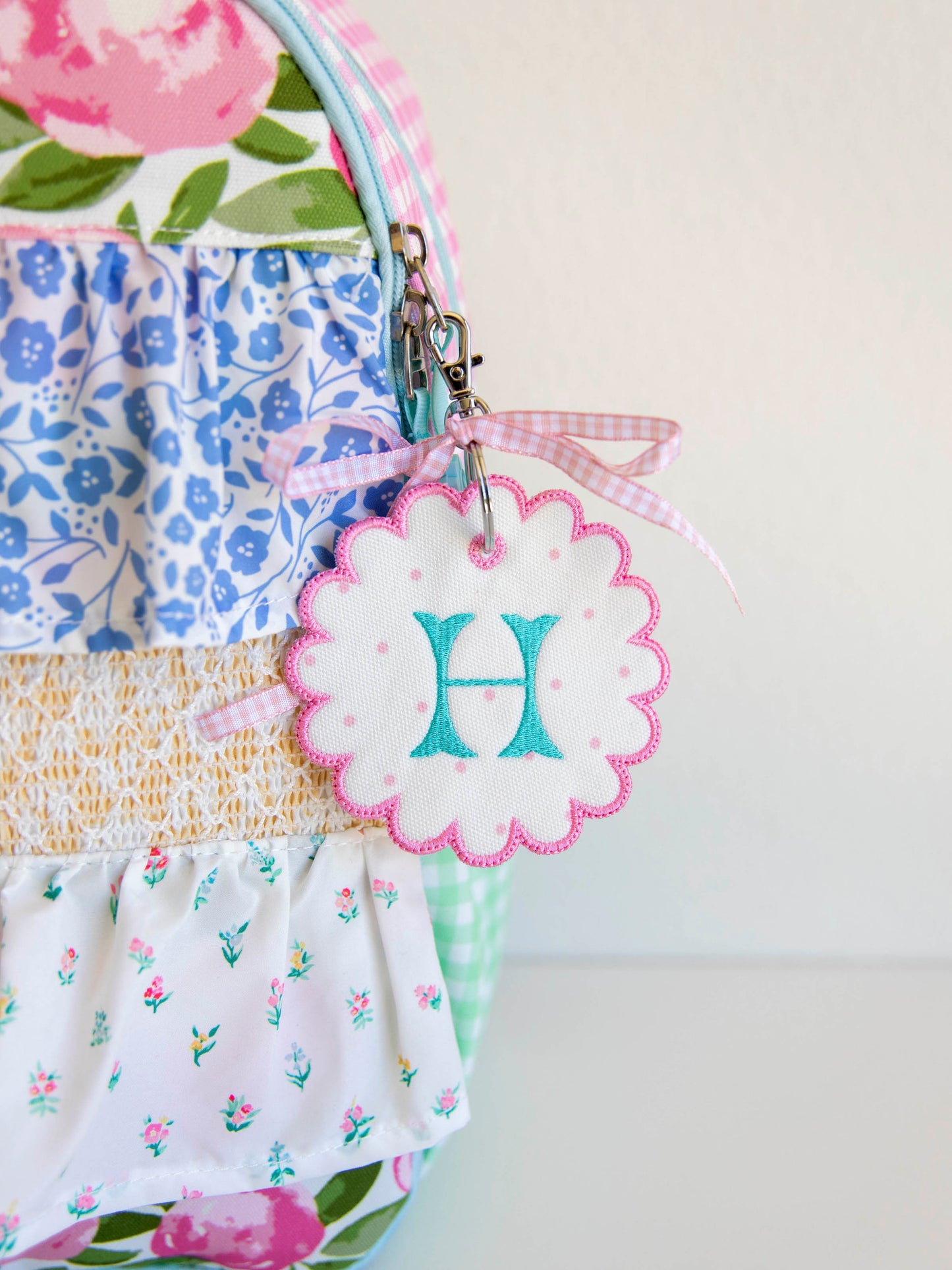 Close up of a customized embroidery tag on a floral colorful backpack