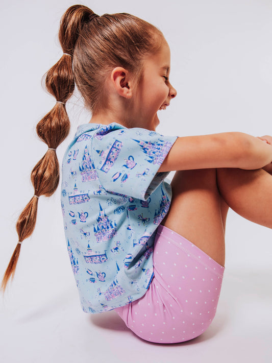 Serve up style and fun with our girls’ “Most Magical” active set, designed for comfort, movement, and everyday play. This adorable sleeveless dress features a whimsical print inspired by magical castles, carousels, and fairy-tale adventures — perfect for little dreamers who love both sports and sparkle. The lightweight, stretchy performance fabric keeps her cool and comfortable from the court to the playground, while the flowy shirt design and active shorts allows for easy twirls and active fun.