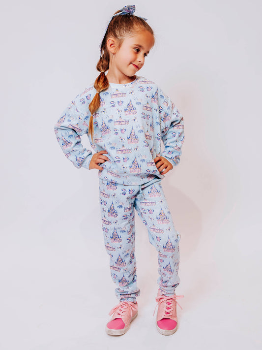 Cozy up in enchanted style with our Most Magical Sweat Set! Featuring a dreamy print of castles, teacups, and fireworks on a soft pastel background, this girls’ sweat set brings all the comfort and charm of your favorite fairytale. Made from ultra-soft fabric with a relaxed fit, the sweatshirt and jogger pants are perfect for playtime, travel days, or snuggling up at home. Magical comfort meets everyday wear!