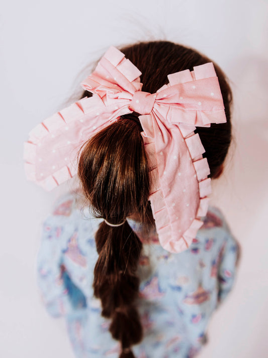 Add the perfect finishing touch to any outfit with our Pleated Bow! This classic girls’ hair bow features soft, textured pleats that create a timeless look for every occasion — from school days to special celebrations. Attached to a secure alligator clip, it stays perfectly in place through every twirl and playdate. Available in a variety of colors to match all her favorite SweetHoney styles, this bow is both stylish and sweet — a must-have accessory for every little girl’s wardrobe.