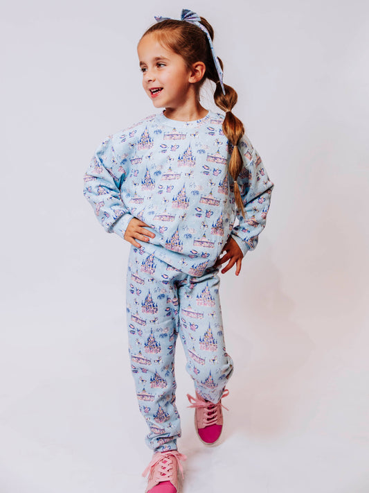 Cozy up in enchanted style with our Most Magical Sweat Set! Featuring a dreamy print of castles, teacups, and fireworks on a soft pastel background, this girls’ sweat set brings all the comfort and charm of your favorite fairytale. Made from ultra-soft fabric with a relaxed fit, the sweatshirt and jogger pants are perfect for playtime, travel days, or snuggling up at home. Magical comfort meets everyday wear!