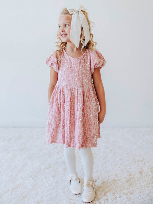 Make every moment shine in our Girls’ Sequin Sparkle Dress, designed for holiday parties, special occasions, and picture-perfect moments. Crafted from 100% polyester, this dress features a soft velvet-like texture that’s gentle on the skin and a smooth interior lining for all-day comfort. The fabric is covered in shimmering transparent sequins that catch the light beautifully, creating a dazzling effect with every twirl.