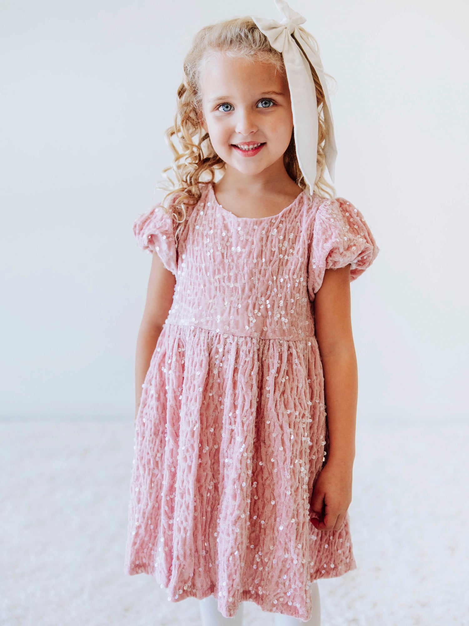 Make every moment shine in our Girls’ Sequin Sparkle Dress, designed for holiday parties, special occasions, and picture-perfect moments. Crafted from 100% polyester, this dress features a soft velvet-like texture that’s gentle on the skin and a smooth interior lining for all-day comfort. The fabric is covered in shimmering transparent sequins that catch the light beautifully, creating a dazzling effect with every twirl.