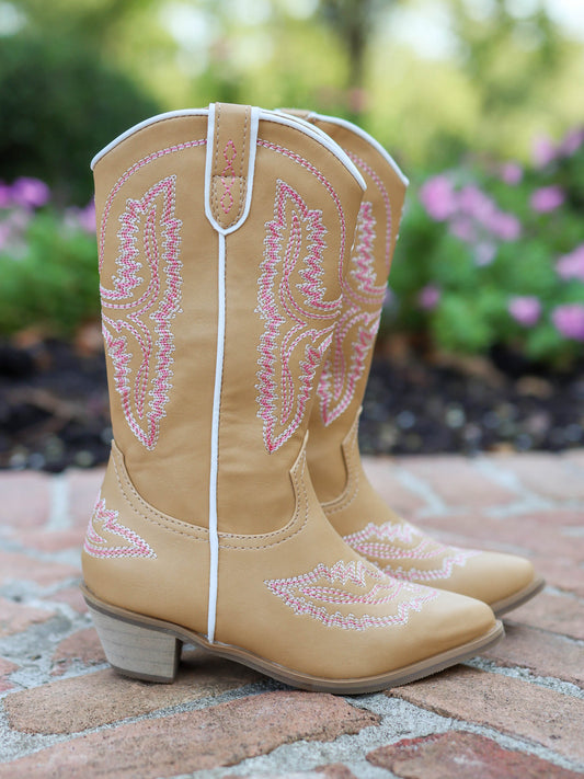 Pair of tan, tall, pointy toed boots with pink decorative stitching all over.