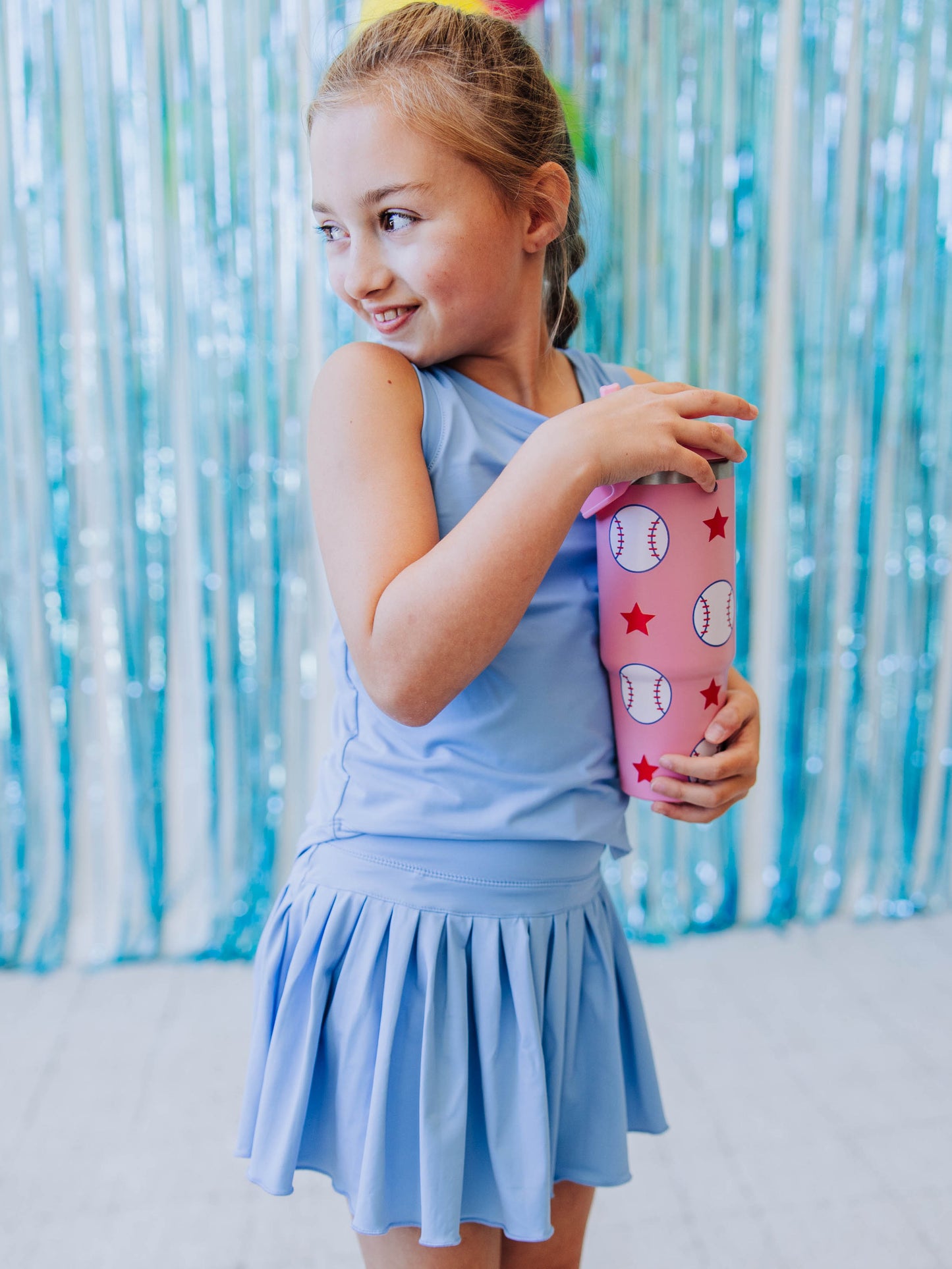 Girl wearing opal blue set holding a softball printed water bottle.