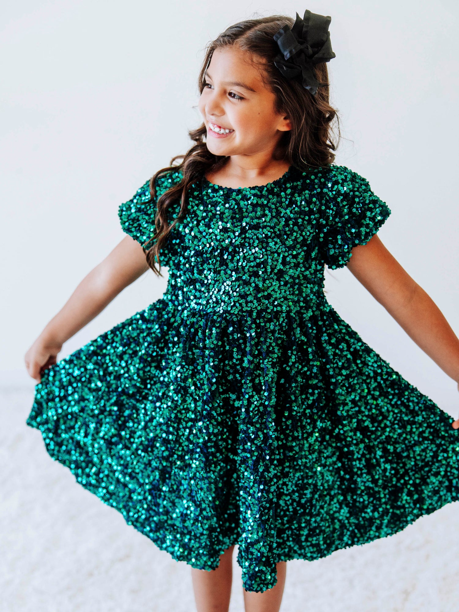 Make her holiday sparkle in our girls’ emerald green sequin dress, designed for festive celebrations, special occasions, and twirl-worthy moments. This stunning sparkle party dress for girls features an allover layer of shimmering green sequins that catch the light from every angle. With a soft interior lining and comfortable puff sleeves, it’s as cozy as it is glamorous.
Perfect for Christmas parties, family photos, and holiday events.