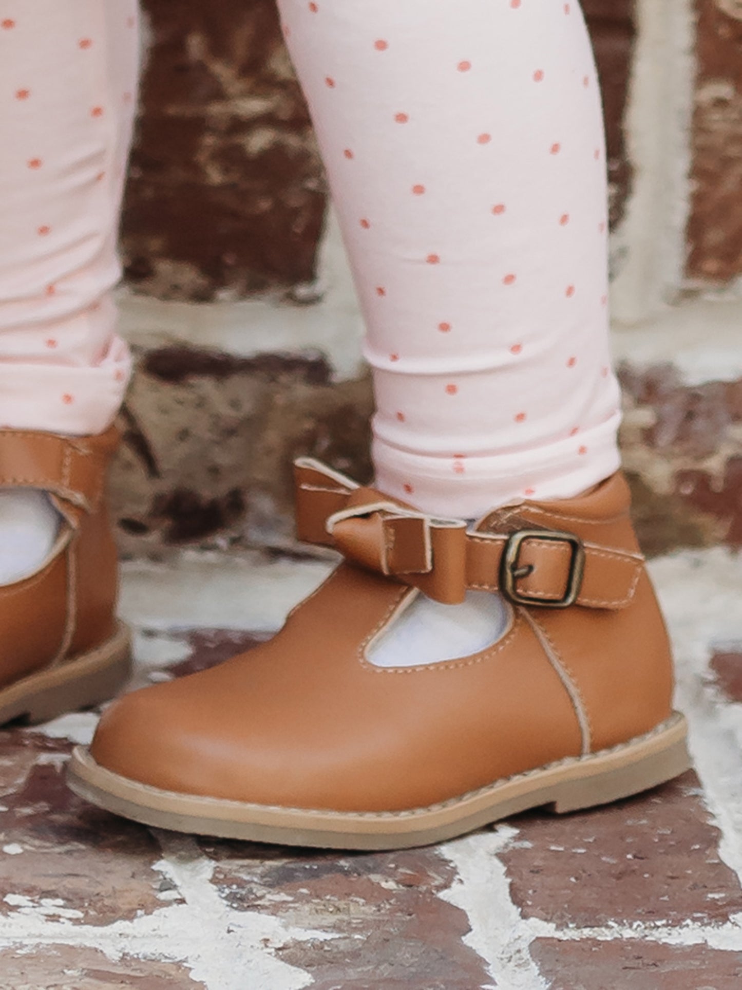 Brown Leather/Manmade material ankle boots with decorative buckle over the velcro closure. Has cute little openings right below the strap for ventilation and to show off your cute socks.
