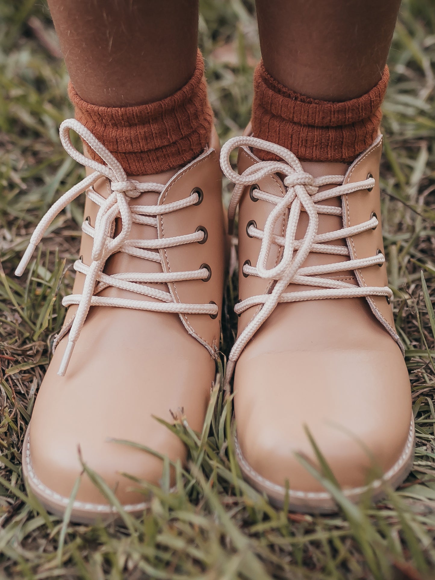 Pair of tan manmade leather Lace Up Ankle Boots with metal grommet eyelet holes and rubber soles.