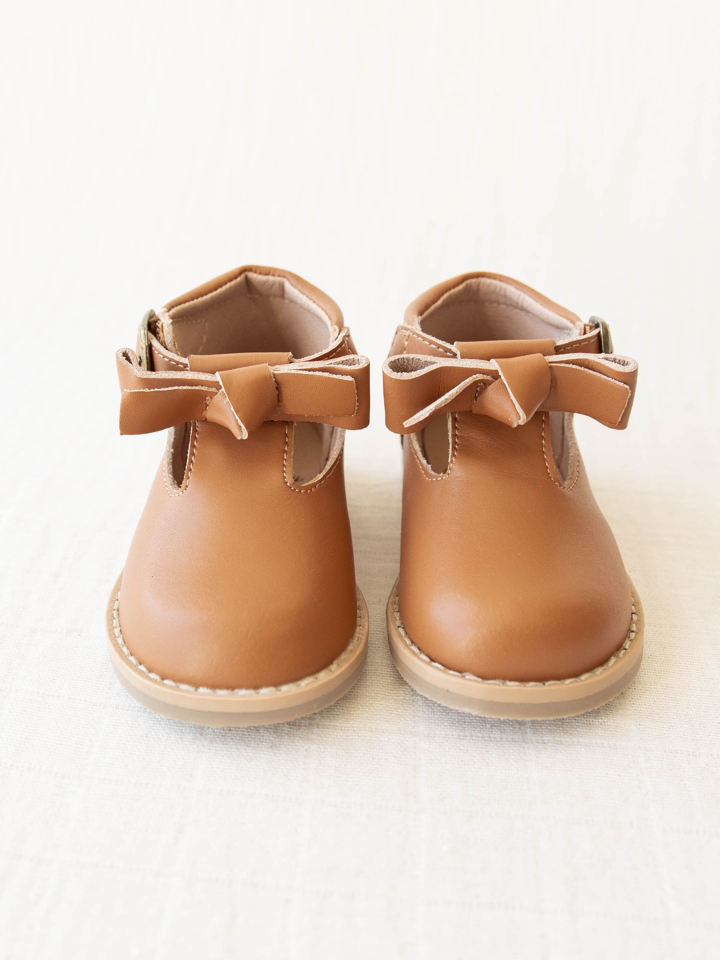 Brown Leather/Manmade material ankle boots with decorative buckle over the velcro closure. Has cute little openings right below the strap for ventilation and to show off your cute socks.