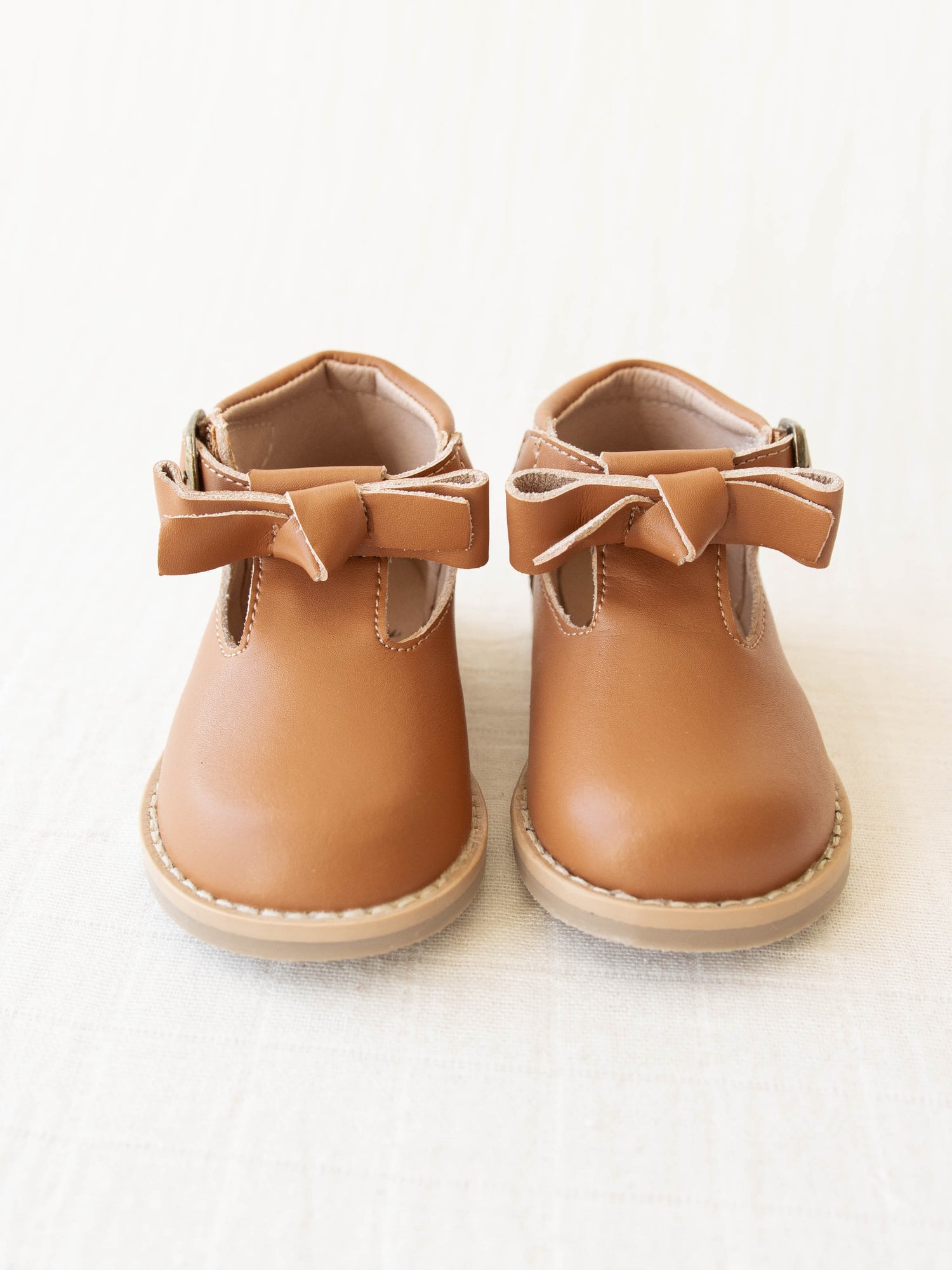 Brown Leather/Manmade material ankle boots with decorative buckle over the velcro closure. Has cute little openings right below the strap for ventilation and to show off your cute socks.