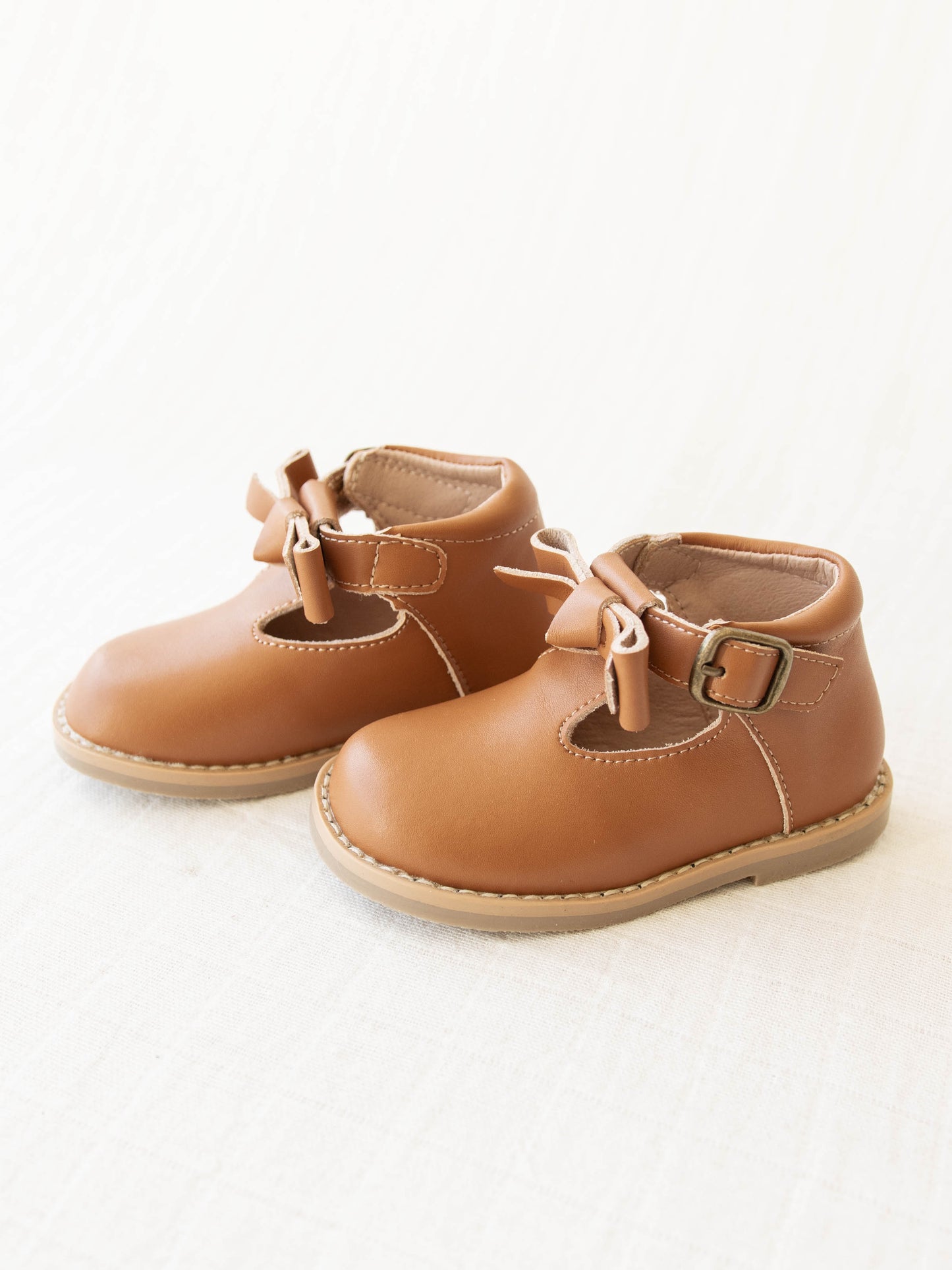 Brown Leather/Manmade material ankle boots with decorative buckle over the velcro closure. Has cute little openings right below the strap for ventilation and to show off your cute socks.