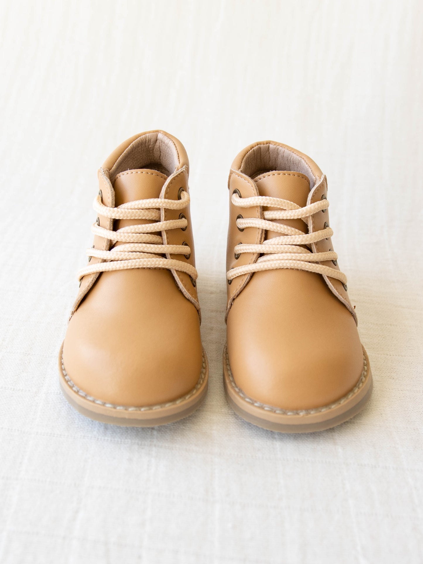 Pair of tan manmade leather Lace Up Ankle Boots with metal grommet eyelet holes and rubber soles.