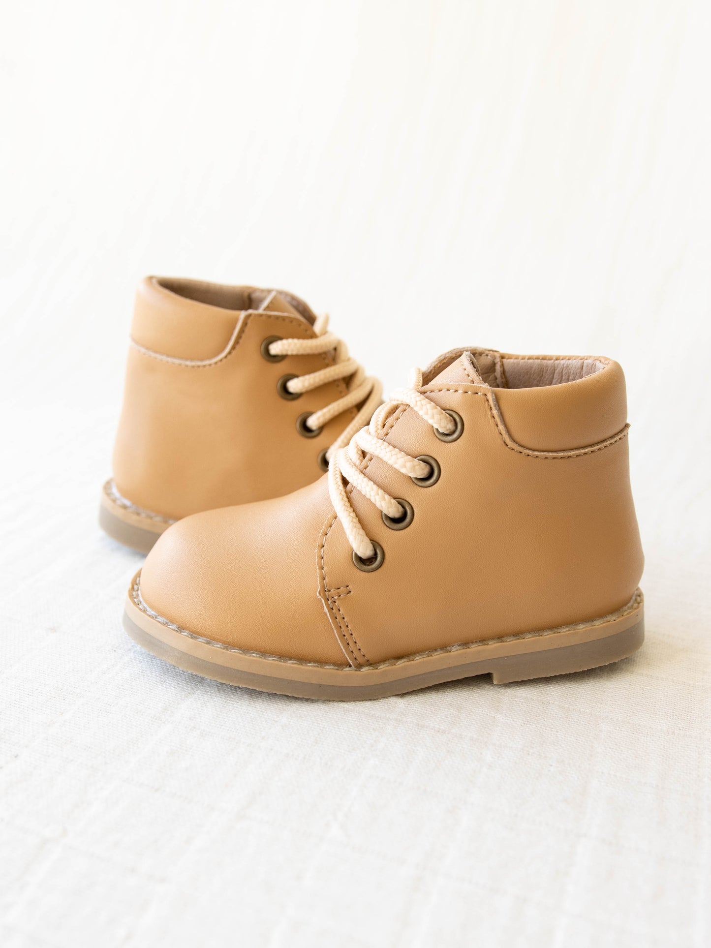 Pair of tan manmade leather Lace Up Ankle Boots with metal grommet eyelet holes and rubber soles.