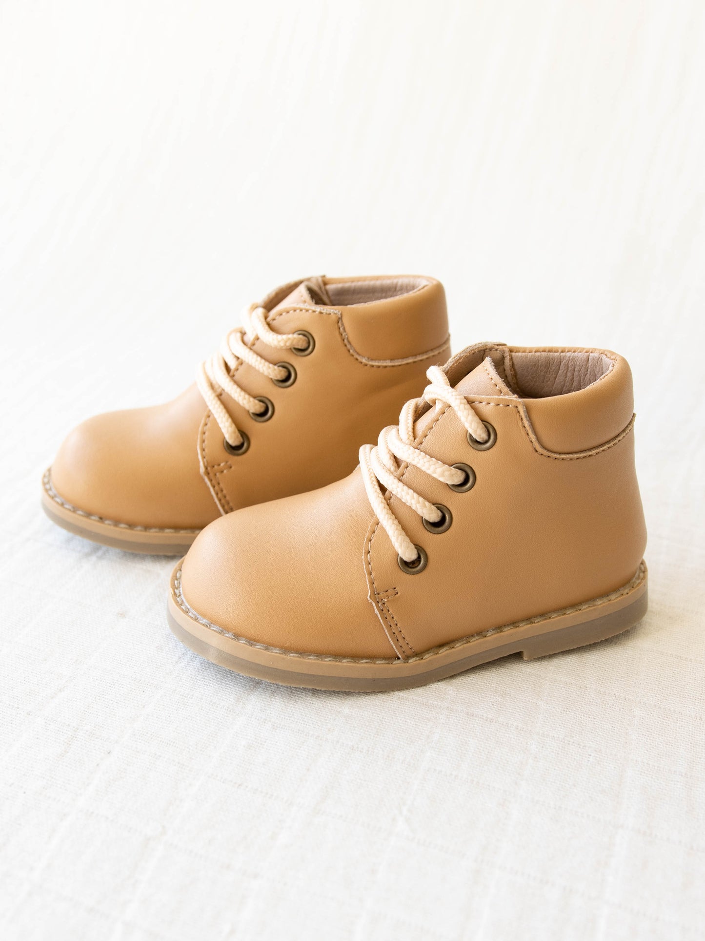 Pair of tan manmade leather Lace Up Ankle Boots with metal grommet eyelet holes and rubber soles.