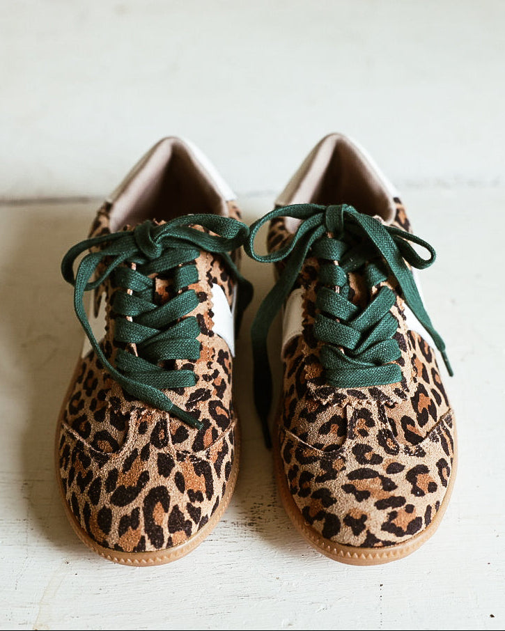 Pair of leooard printed tennis shoes with green laces and rubber sole. 
