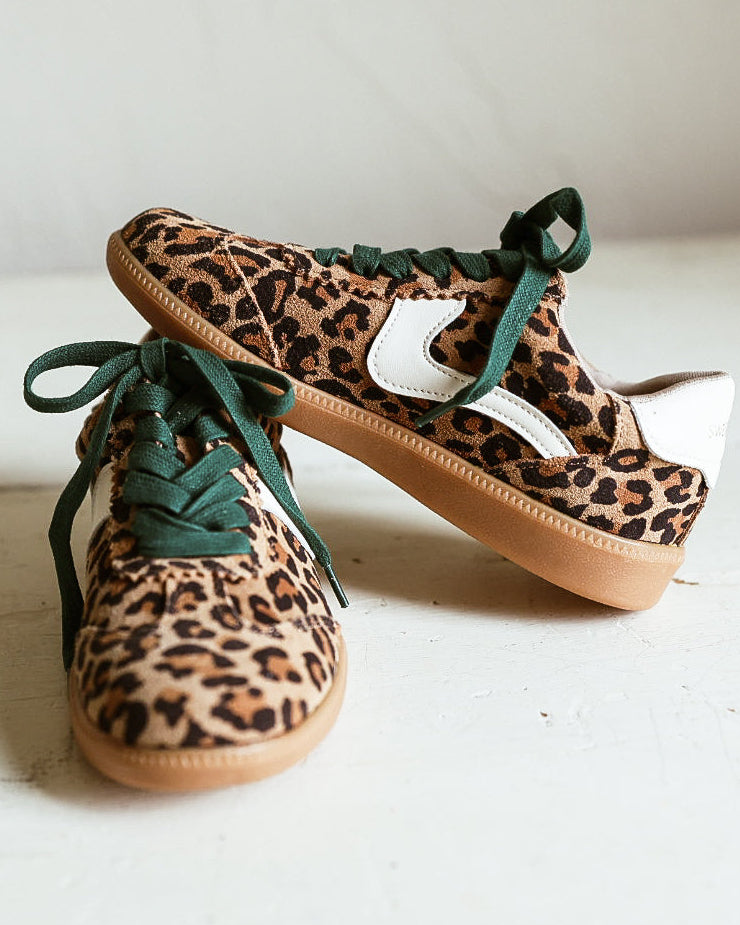 Pair of leooard printed tennis shoes with green laces and rubber sole. 