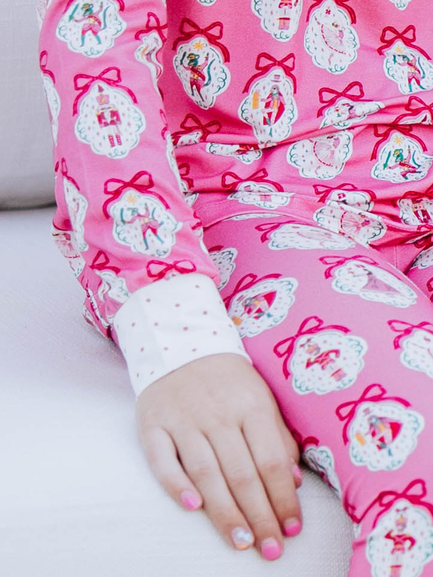 Close up picture of the cuff on pajamas. Cuff is white with pink dots. Overall print on the rest of pajamas are pink nutcrackers. 