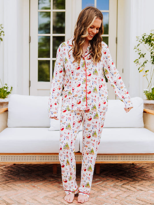 Girl wearing everyday button set pajamas with a north pole pattern. Pajamas are unisex.