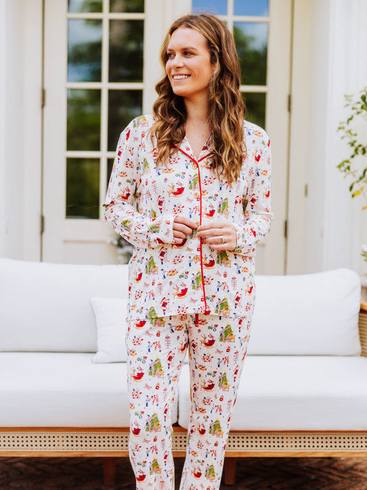 Girl wearing everyday button set pajamas with a north pole pattern. Pajamas are unisex.