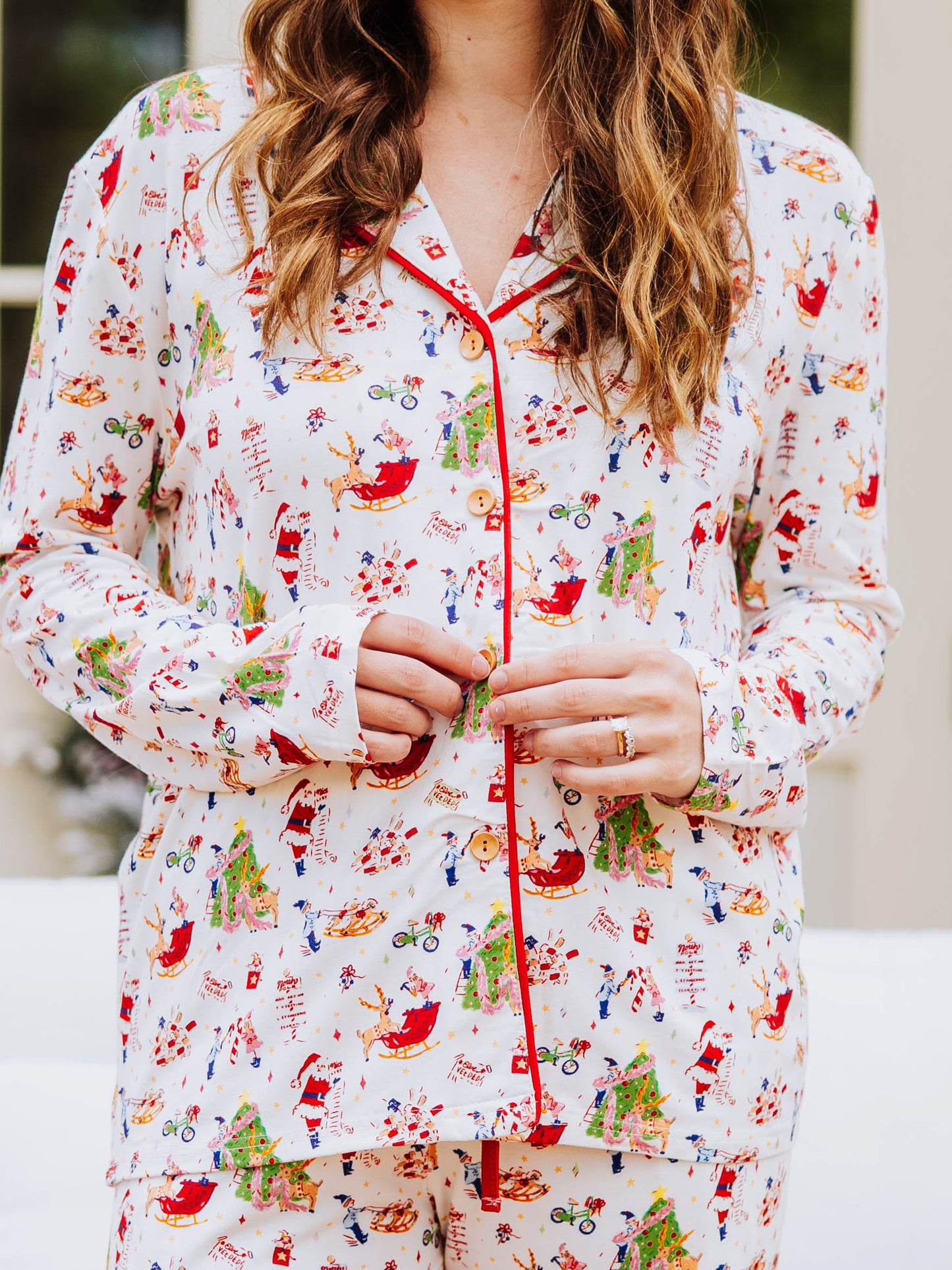 Girl wearing everyday button set pajamas with a north pole pattern. Pajamas are unisex.