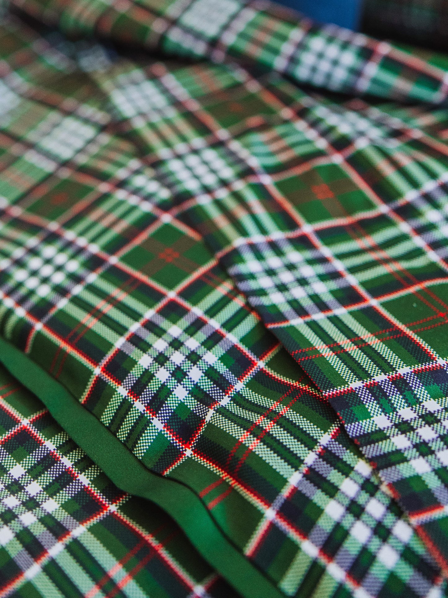 Up close picture of green plaid bedding print. 