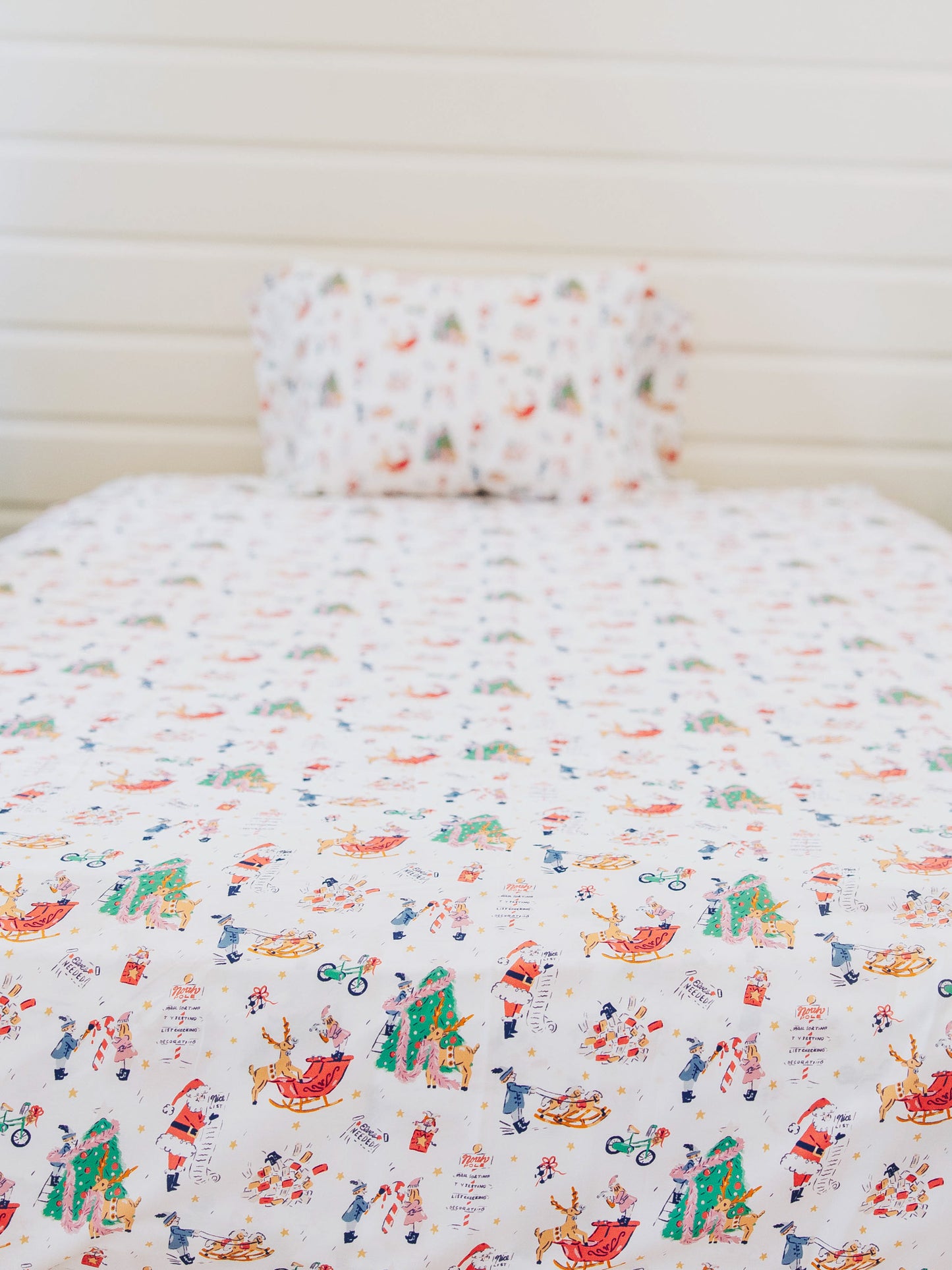 Holiday themed sheets on made up bed. 