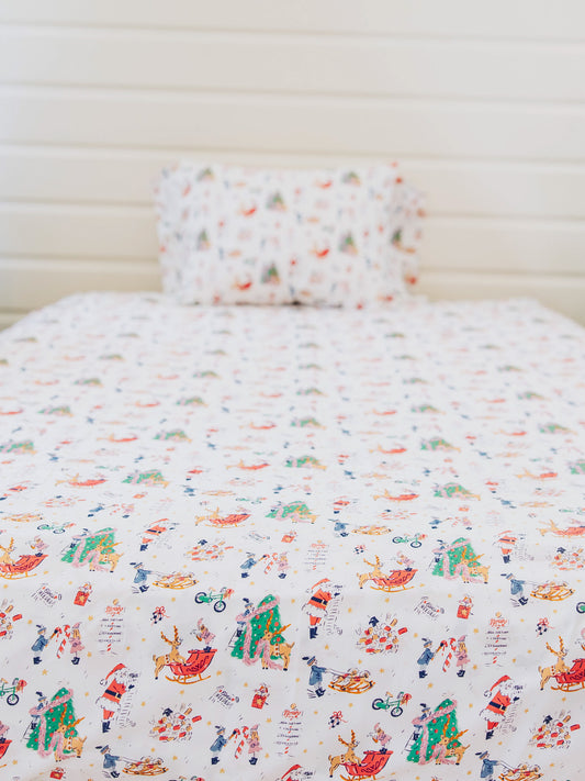 Holiday themed sheets on made up bed. 