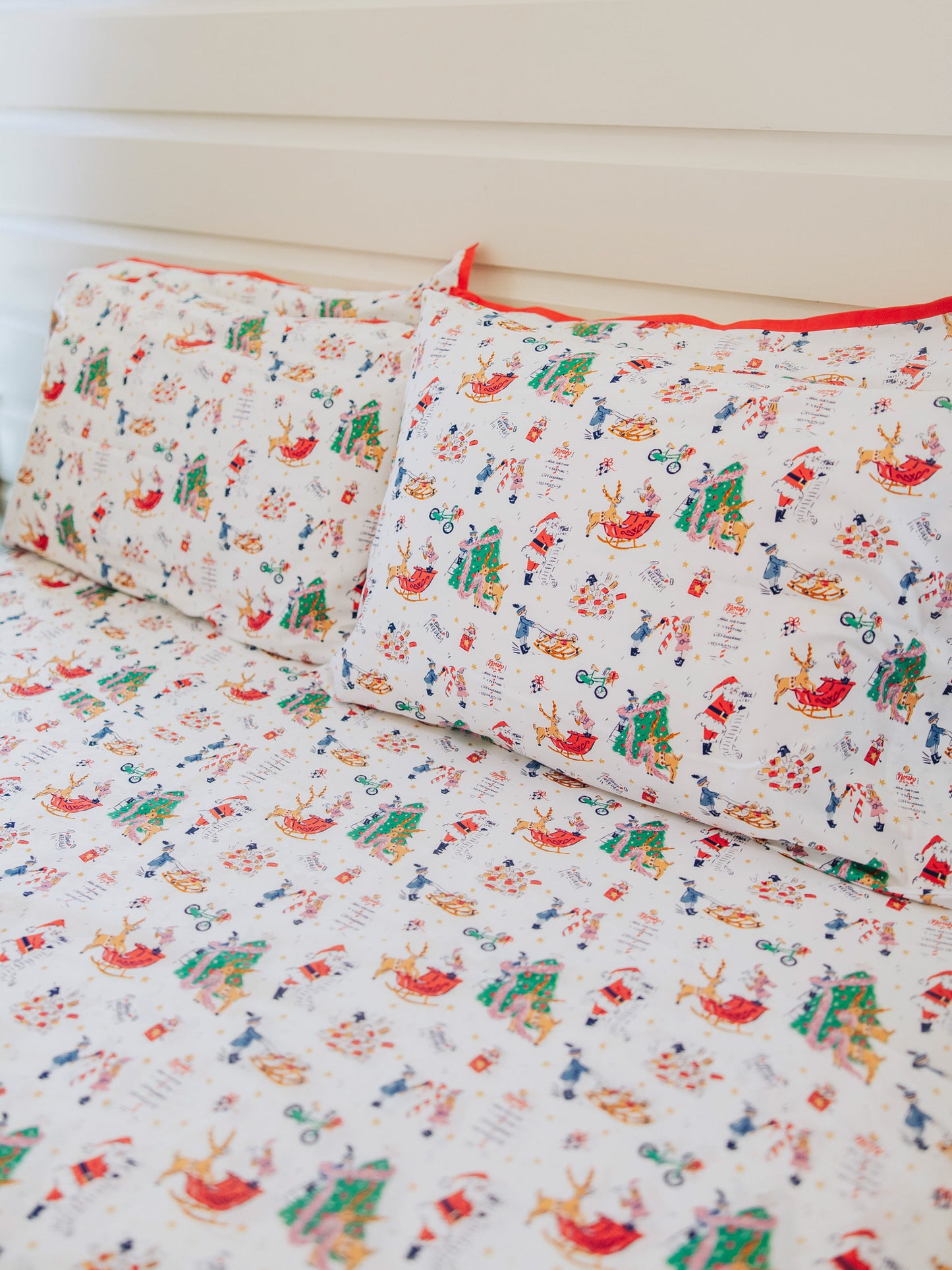 Holiday themed sheets and pillow cases on made up bed. 