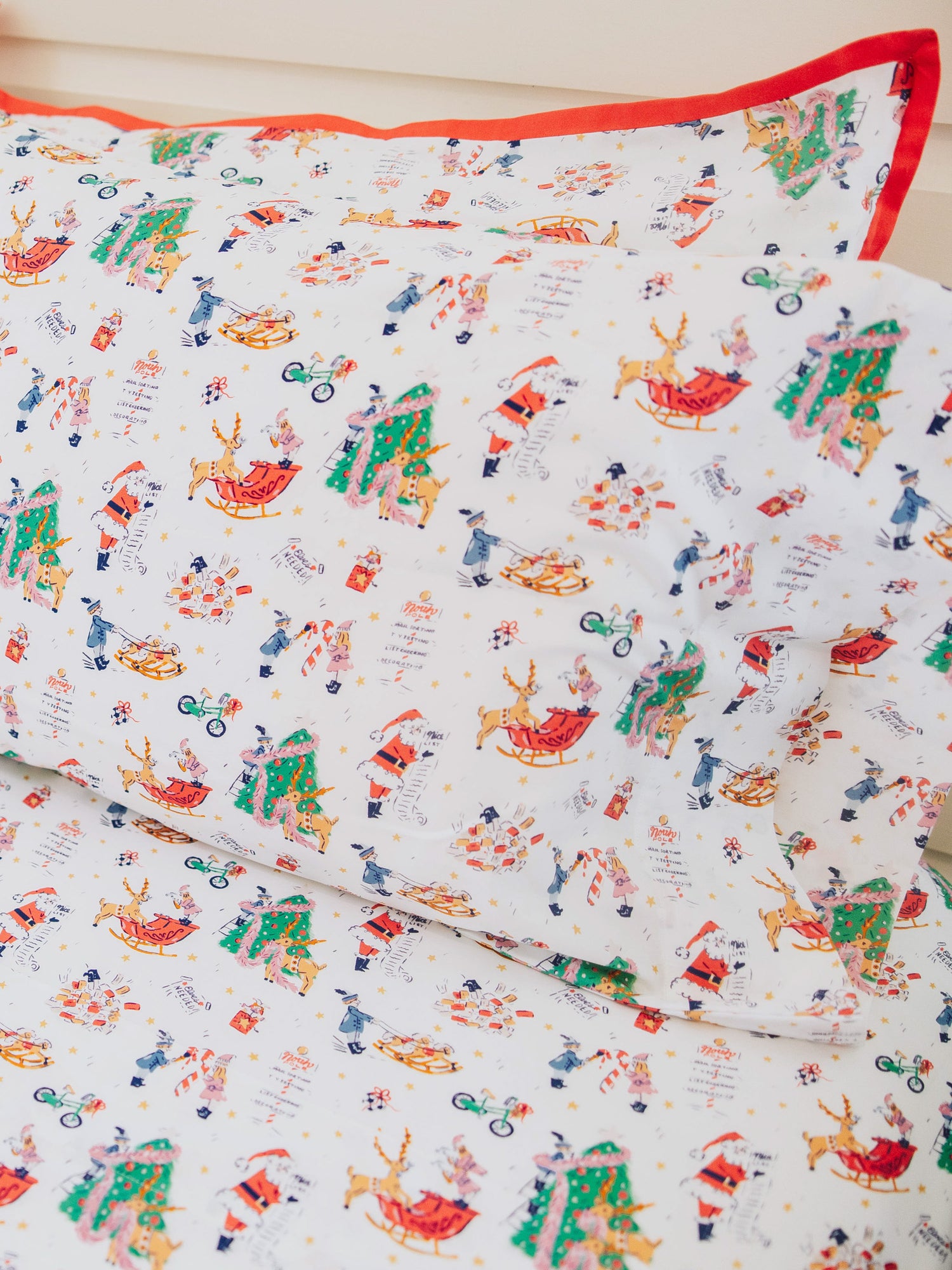 Holiday themed sheets and pillow cases on made up bed. 