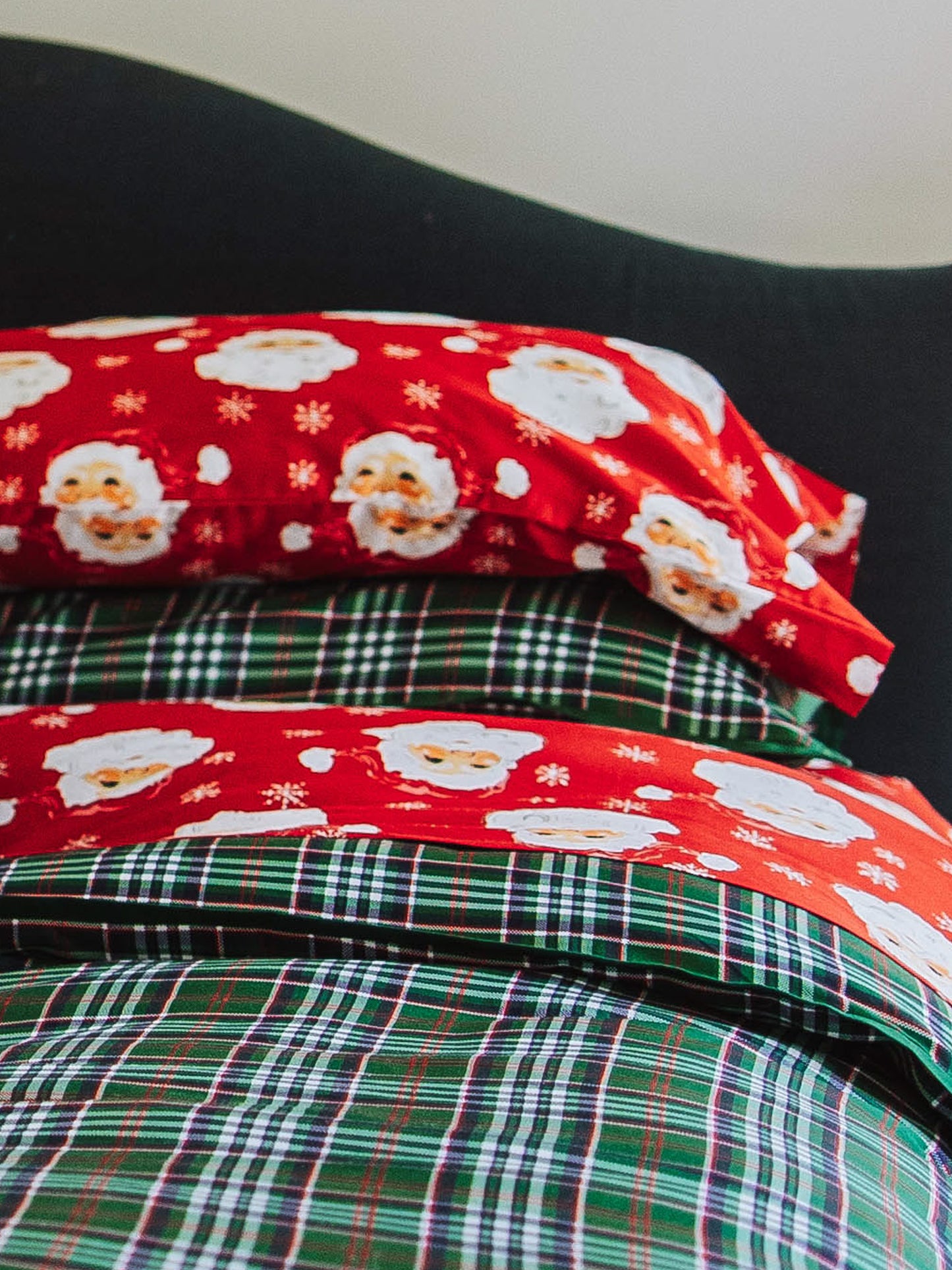 Red santa sheets and pillow on traditional green plaid duvet cover and sham. 