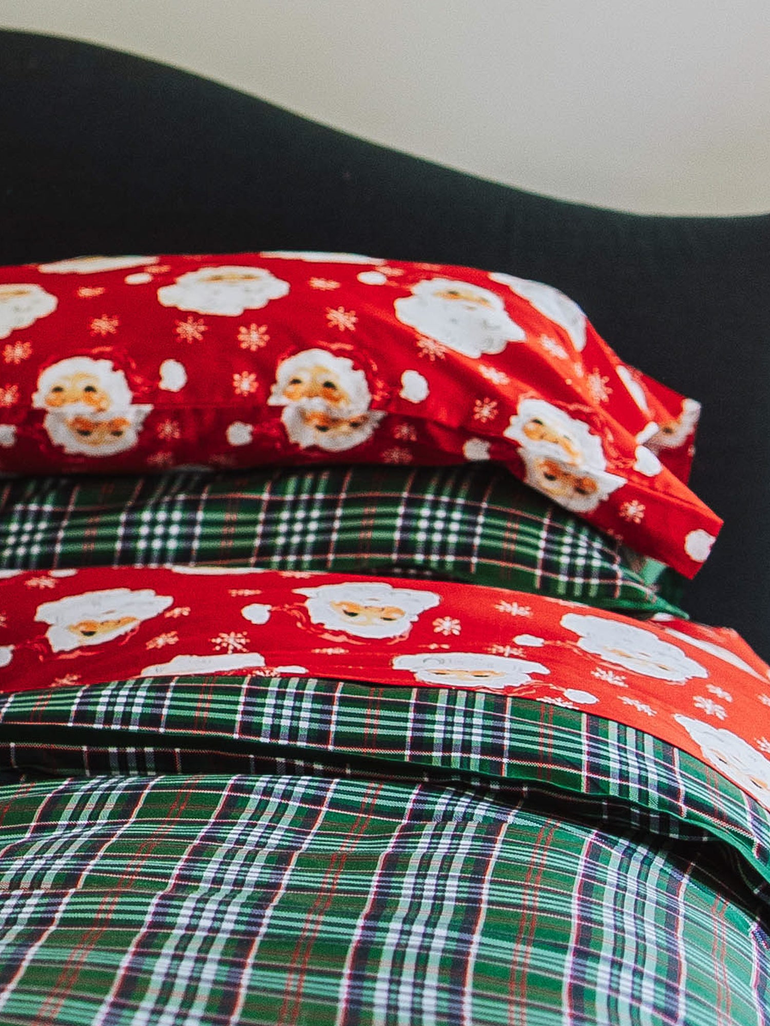 Red santa sheets and pillow on traditional green plaid duvet cover and sham. 