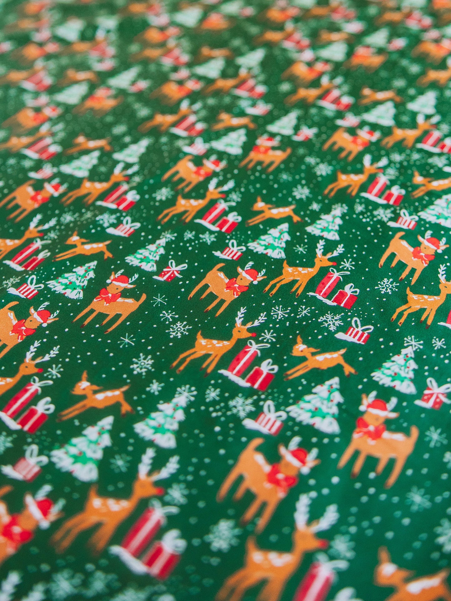 Reindeer printed sheets shown on made up bed.