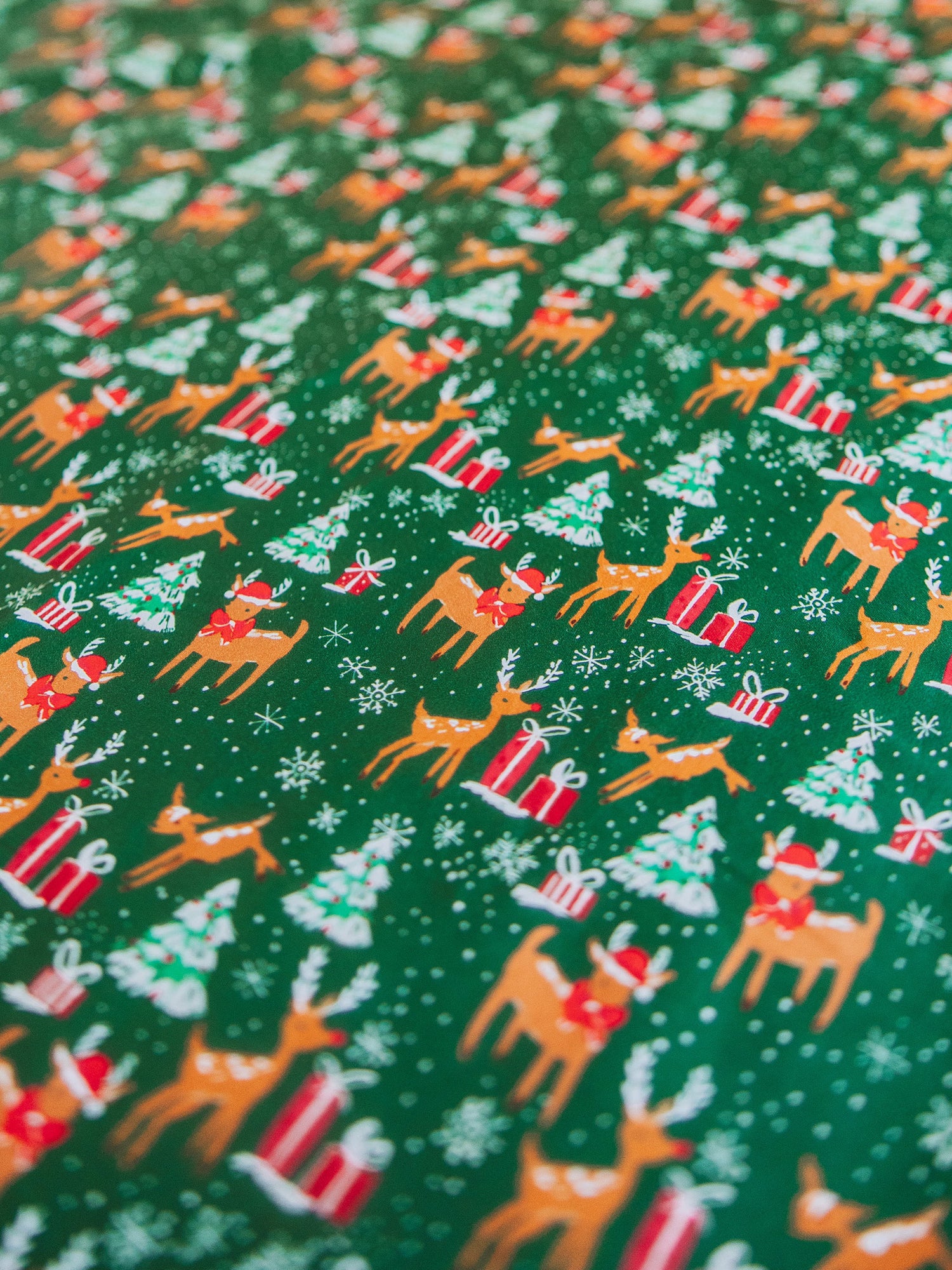 Reindeer printed sheets shown on made up bed.