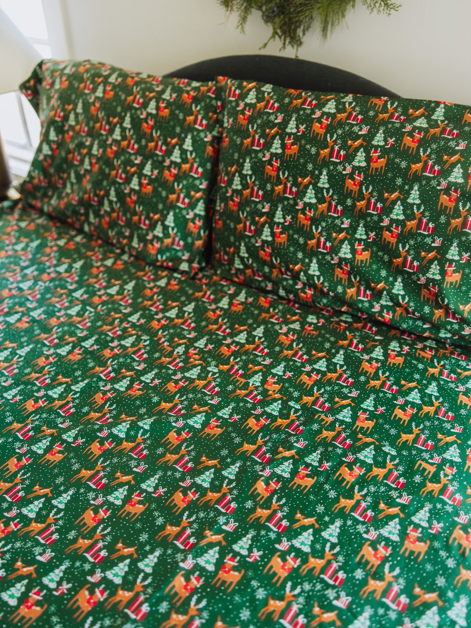 Reindeer printed sheets shown on made up bed.