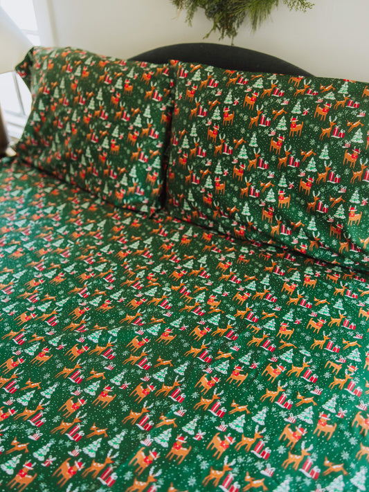 Reindeer printed sheets shown on made up bed.