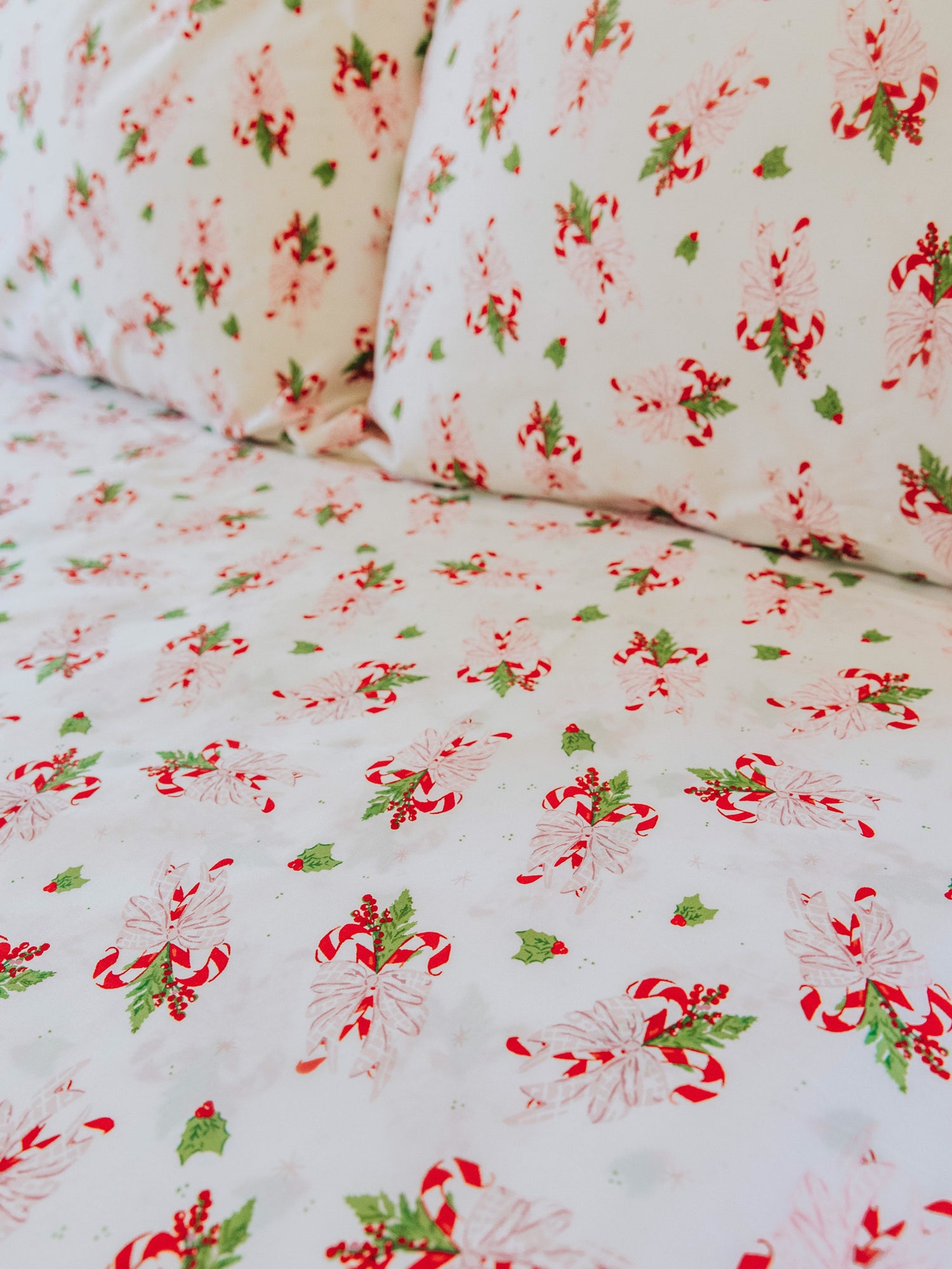 Holiday themed sheets and pillow cases on made up bed. 